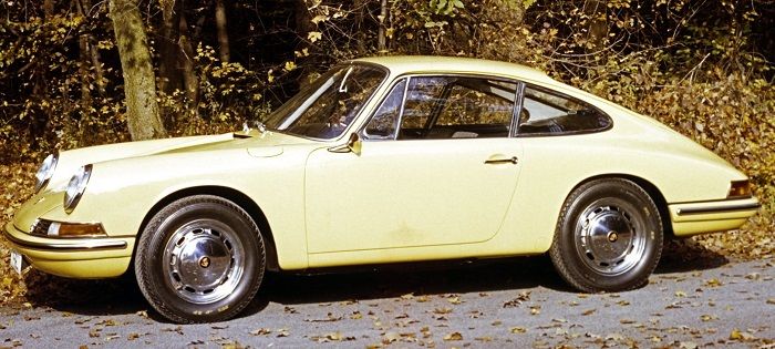Ein gelber Porsche Baujahr 1963 steht auf einem Waldweg