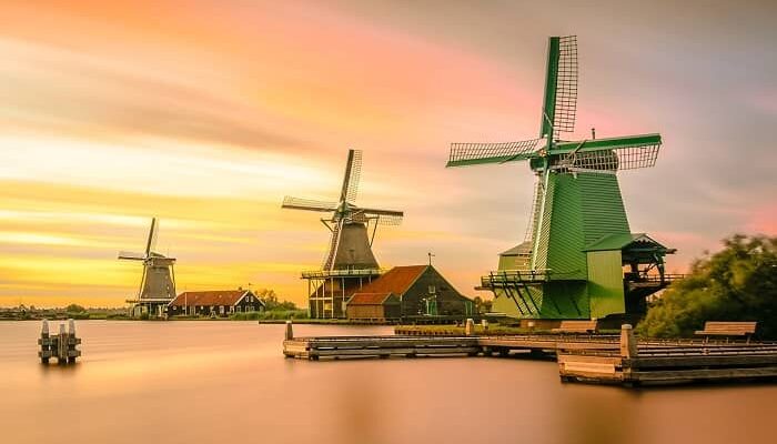 Drei Große Windmühlen stehen an einem Wasser