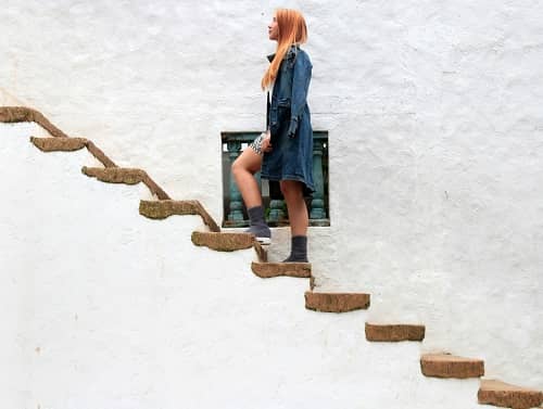 Eine Frau steigt eine schmale Treppe empor