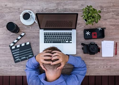 Ein Mann sitzt wütend und gestresst über seinem Laptop