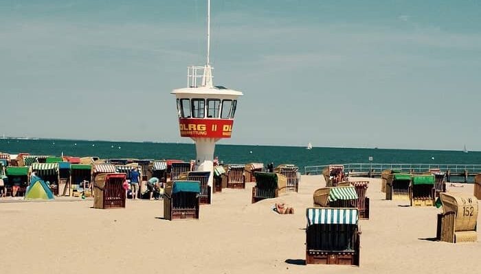 Ein Sandstrand mit einem Wasserwachtturm und vielen Strandkörben