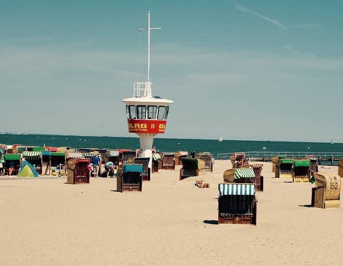 Ein Sandstrand mit einem Wasserwachtturm und vielen Strandkörben