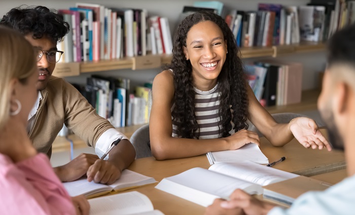 Eine Dreiergruppe Schüler sitzen bei Ihrem Lehrer und lernen